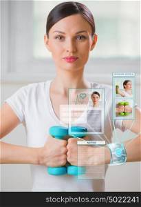 Woman doing exercise with dumbbells wearing smart wearable device with futuristic interface