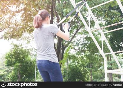Woman doing exercise with TRX in the park, Healthy and wellness