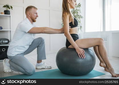 woman doing exercises with ball physiotherapist