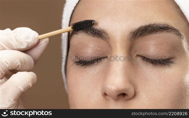 woman doing eyebrow treatment her client