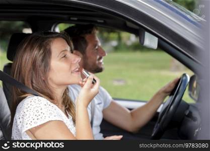 woman doing her make up in the car