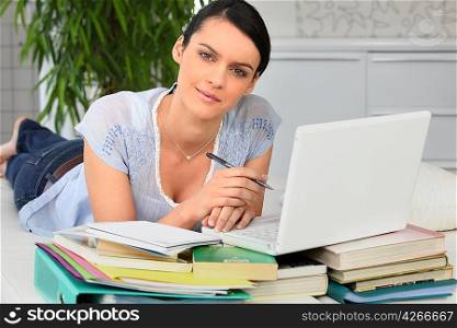 Woman doing homework, laid on a couch