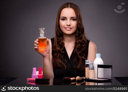 Woman doing makeup on dark background