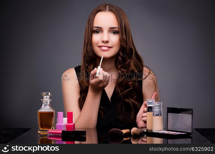 Woman doing makeup on dark background