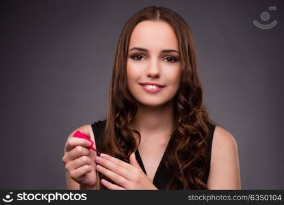 Woman doing makeup on dark background