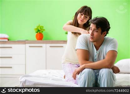 Woman doing massage to her husband in bedroom 