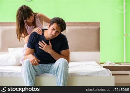 Woman doing massage to her husband in bedroom 