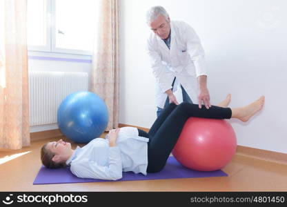 woman doing physiotherapy exercises with fitness ball