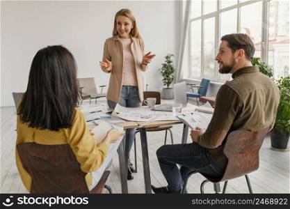 woman doing presentation front her colleagues
