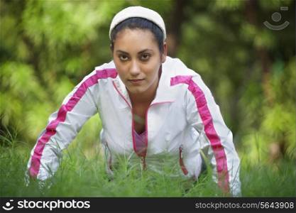Woman doing push-up on grass