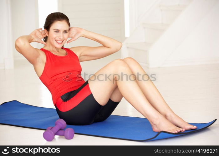 Woman doing sit-ups in home gym