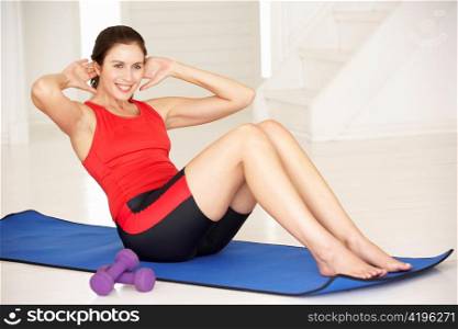 Woman doing sit-ups in home gym