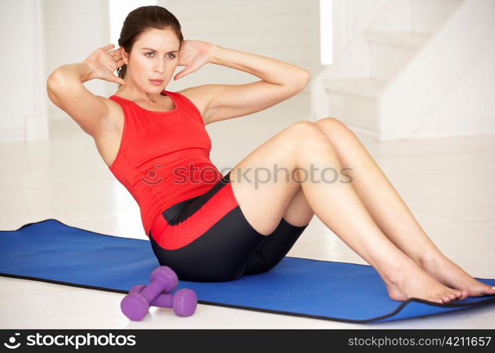 Woman doing sit-ups in home gym