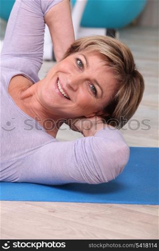 Woman doing sit-ups on a yoga mat