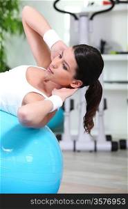 Woman doing sit-ups on gym ball
