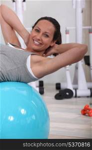 woman doing sit-ups on gym ball