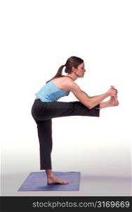 Woman Doing Standing Yoga Pose on Blue Mat