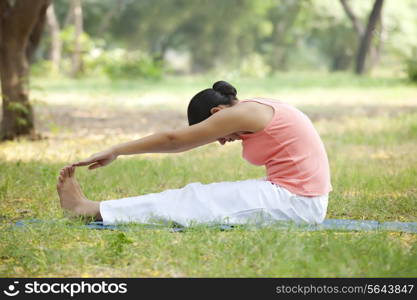Woman doing stretching exercise at lawn