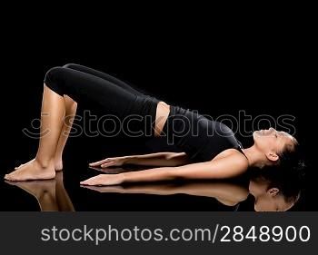 Woman doing stretching exercise on the floor with eyes closed