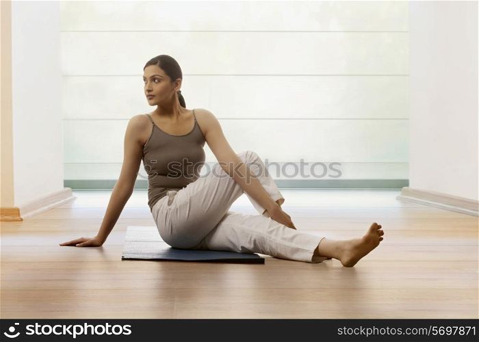 Woman doing stretching exercise on yoga mat