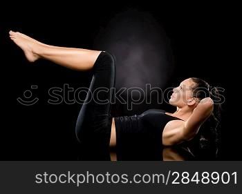 Woman doing stretching exercise with raised legs on the floor