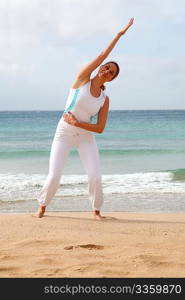 Woman doing stretching exercises at the beach