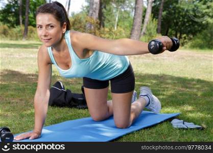 woman doing various exercises with dumbbell and mat