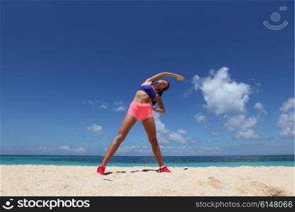 Woman doing workout on beach. Beautiful young woman doing workout on tropical beach