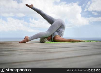 Woman doing yoga by waterfront