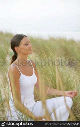 Woman doing yoga in a field