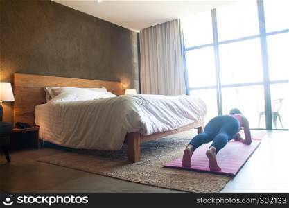 Woman doing yoga in bedroom. Healthy lifestyle concept