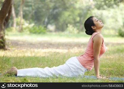 Woman doing yoga in lawn
