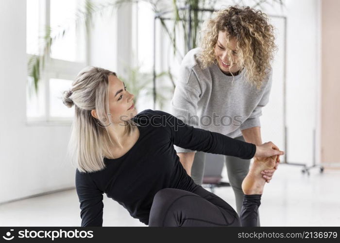 woman doing yoga with teacher