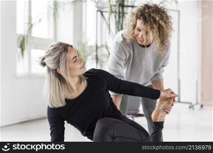 woman doing yoga with teacher
