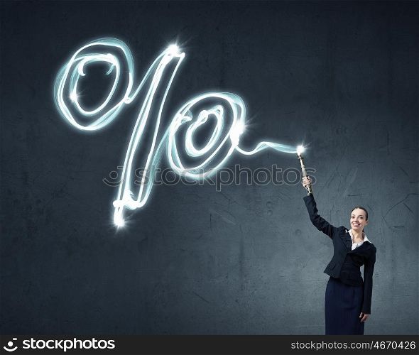 Woman drawing with lantern light. Businesswoman in darkness drawing percentage sign with flashlight