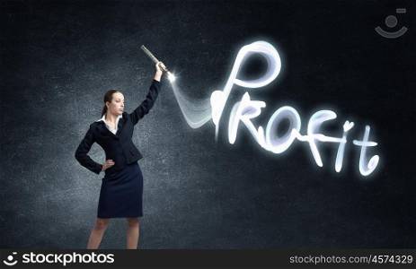 Woman drawing with lantern light. Businesswoman in darkness drawing profit word with flashlight