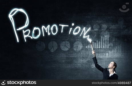 Woman drawing with lantern light. Businesswoman in darkness drawing word promotion with flashlight