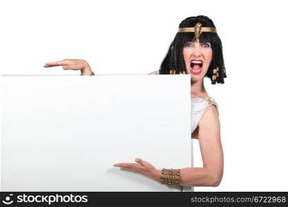 Woman dressed as Cleopatra pointing to a blank sign