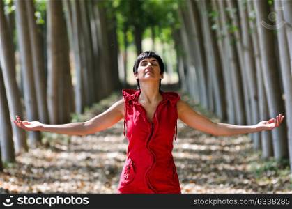 Woman dressed in red, meditating in the forest