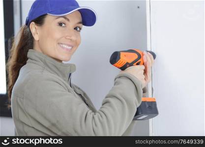 woman drilling wall in new house