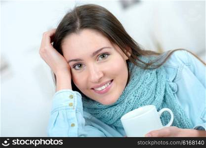 Woman drinking a cup of coffee on the sofa