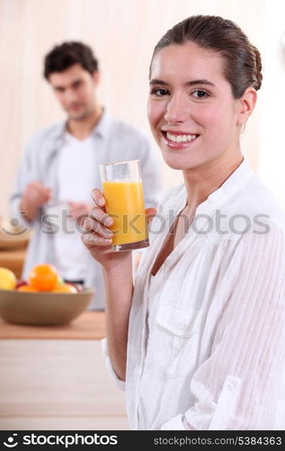 Woman drinking a glass of orange juice for breakfast