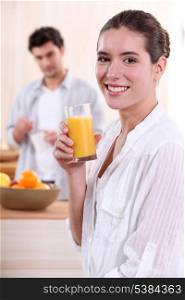 Woman drinking a glass of orange juice for breakfast
