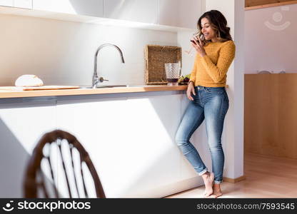 Woman drinking a glass of wine in a modern kitchen