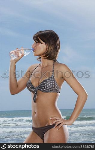 Woman Drinking Bottled Water on Beach