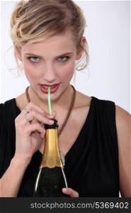 Woman drinking champagne through a straw
