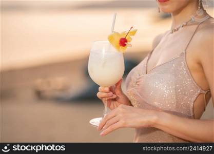 Woman drinking cocktails on the beach, romantic sunset moment. summer vacation.