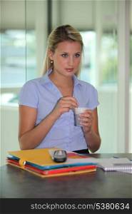 Woman drinking coffee at her desk