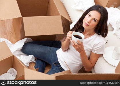 Woman Drinking Coffee Unpacking Boxes Moving House