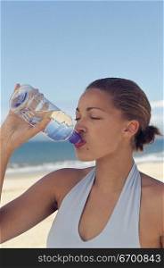 woman drinking from water bottle